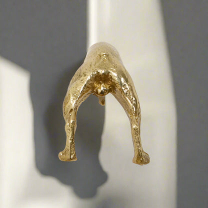 Gold metallic sculpture of a figure on a white background