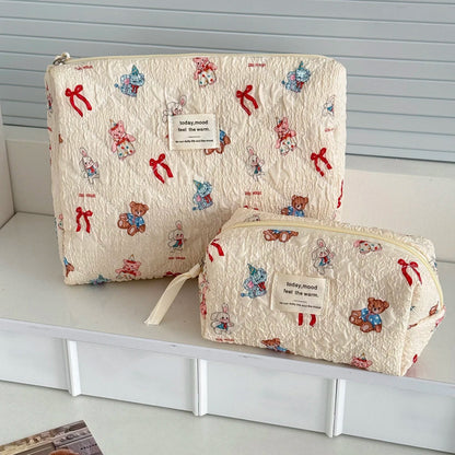 Two patterned pouches with teddy bear designs on a white surface.