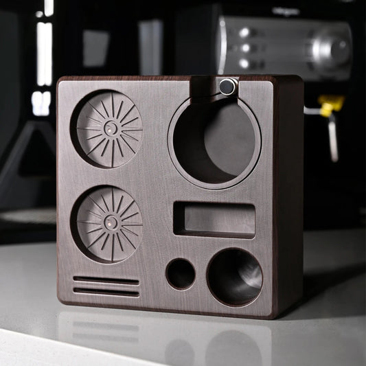 Brass-colored metal block with geometric shapes on a reflective surface