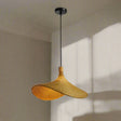 Pendant light with black base and wicker shades on a neutral background.