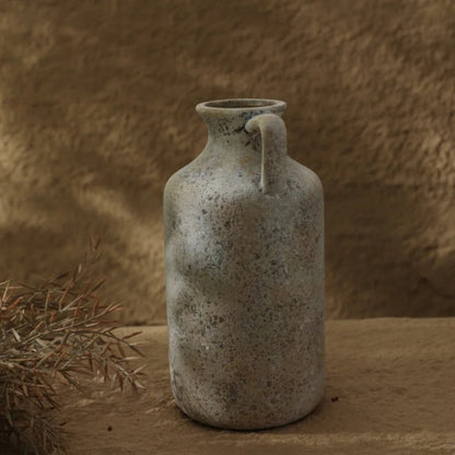 Vintage ceramic jar with a handle on a textured brown background
