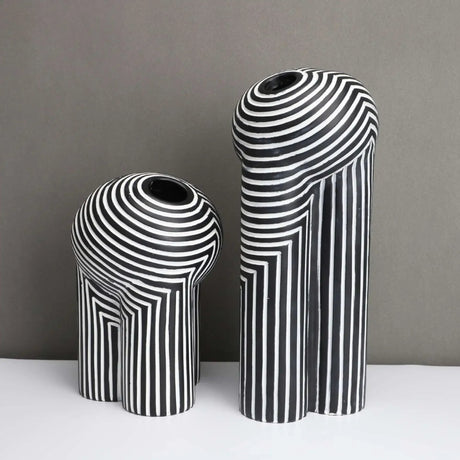 Two black and white striped vases on a gray background