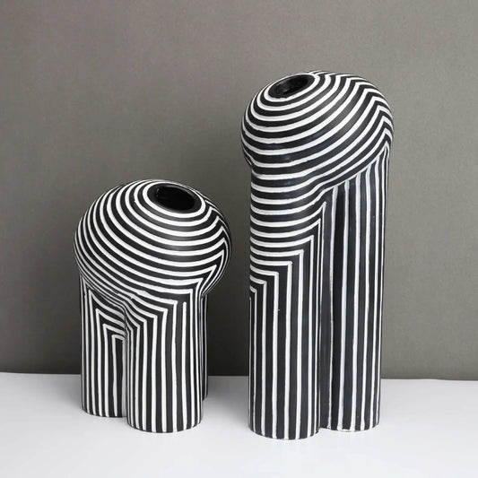 Two black and white striped vases on a gray background