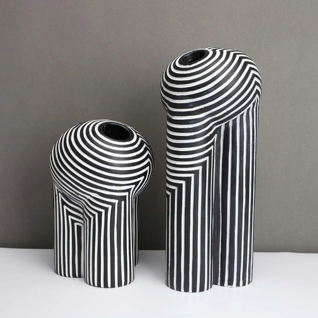 Two black and white striped vases on a gray background