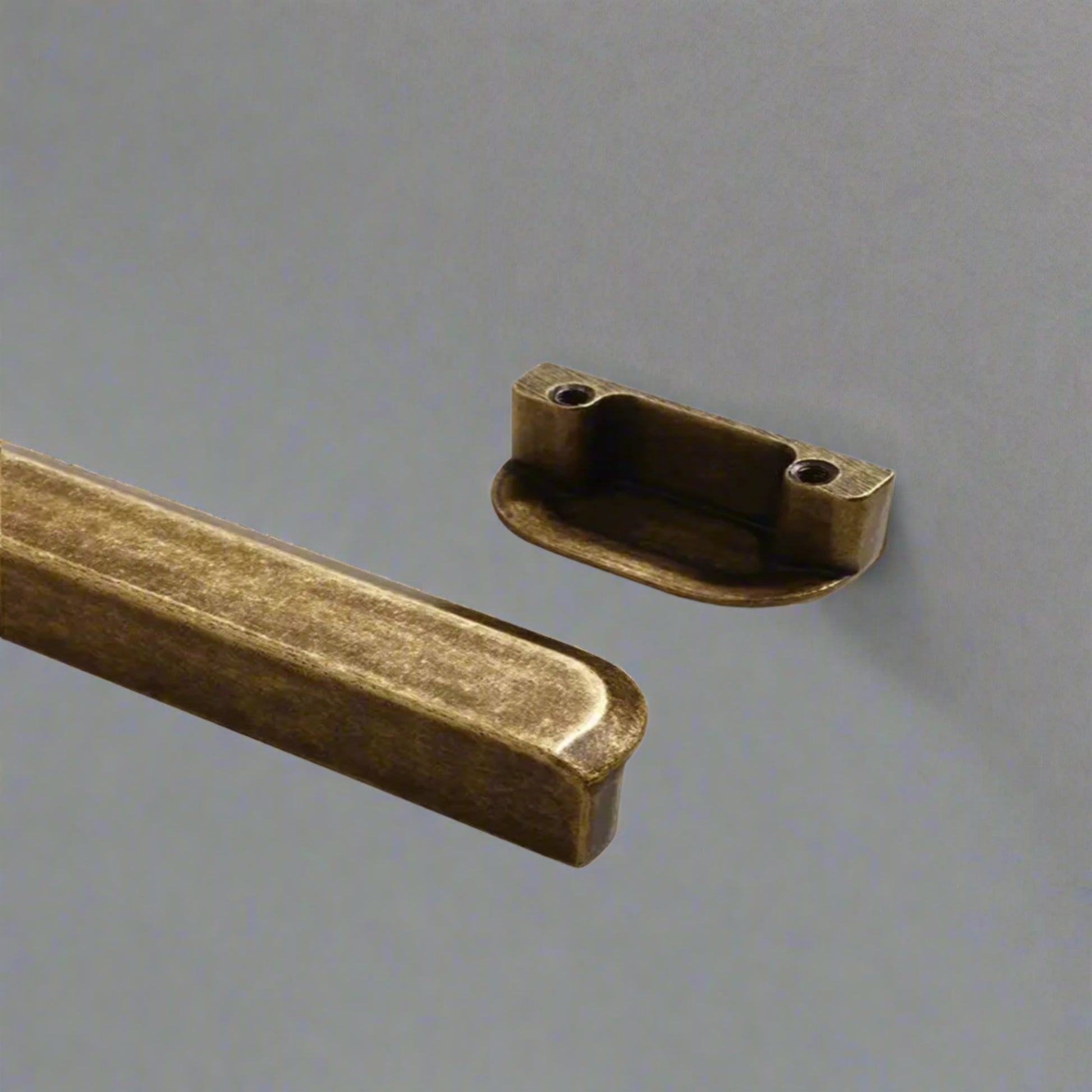 Two bronze metal brackets on a white background