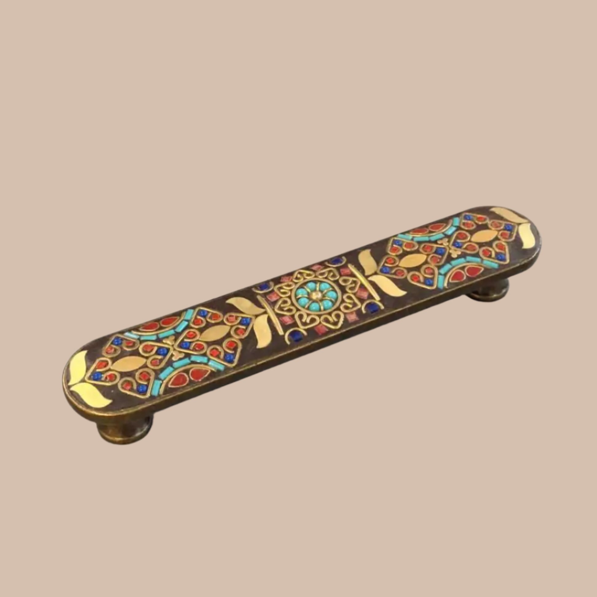 Decorative cabinet handle with colorful inlay on a gray background