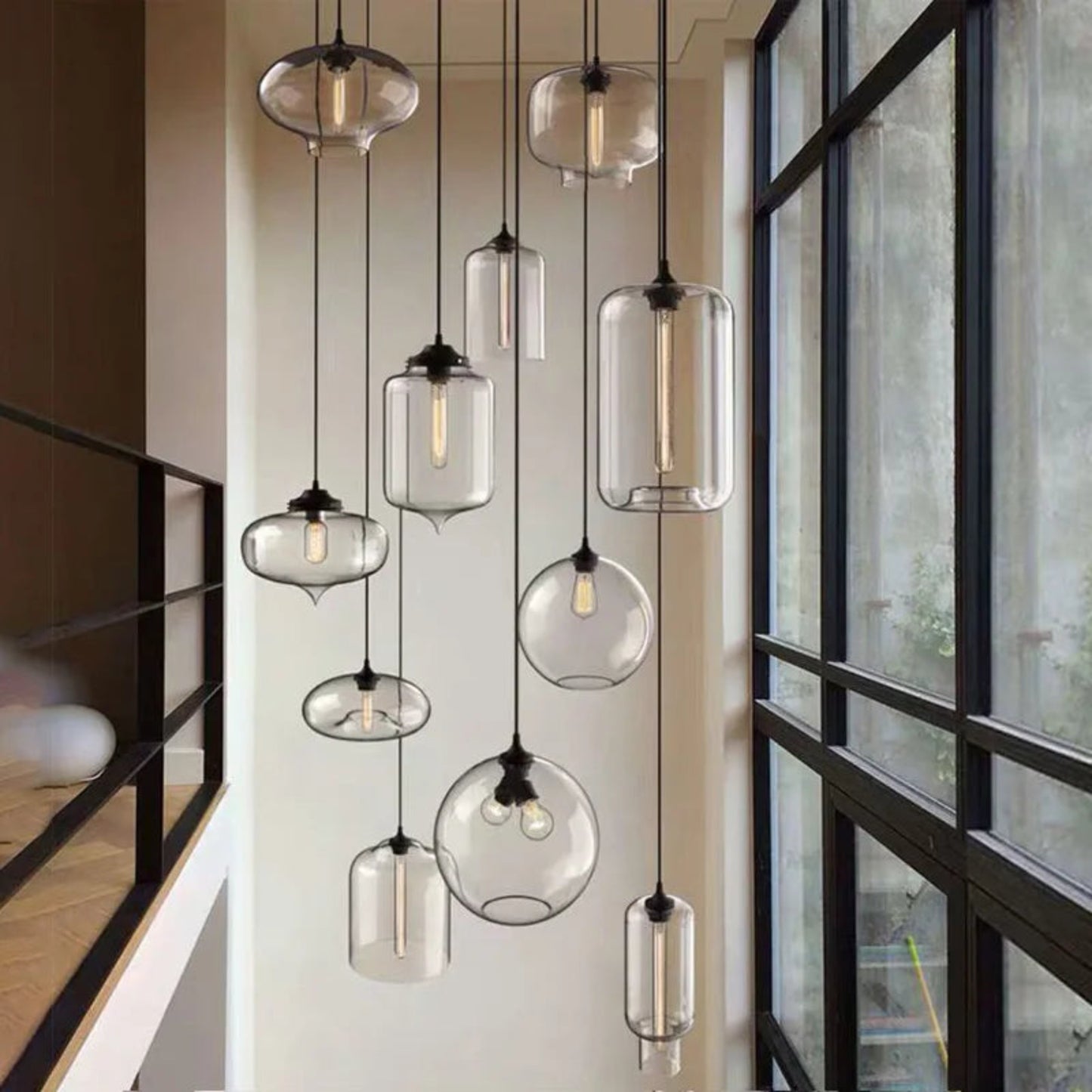 Modern pendant lights with glass shades hanging in a room with large windows.