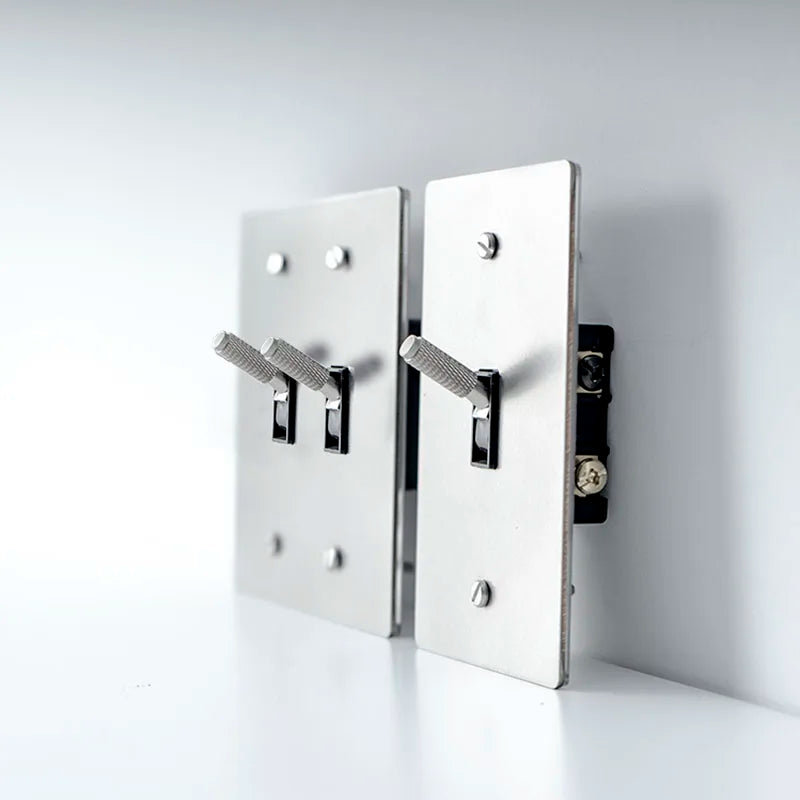Metallic wall-mounted hooks on a white background