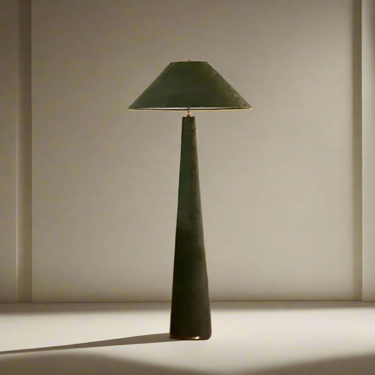 Green floor lamp in a living room setting with a white sofa and wooden chair.

