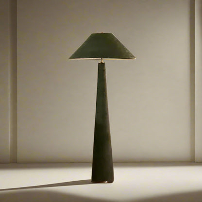Green floor lamp in a living room setting with a white sofa and wooden chair.

