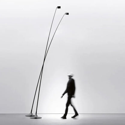 Modern floor lamp with two long poles on a plain background