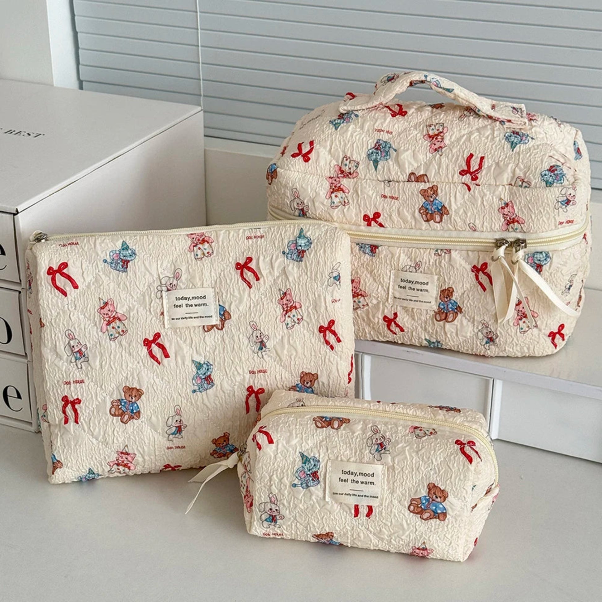 Set of three patterned bags with teddy bear and bow design on a neutral background