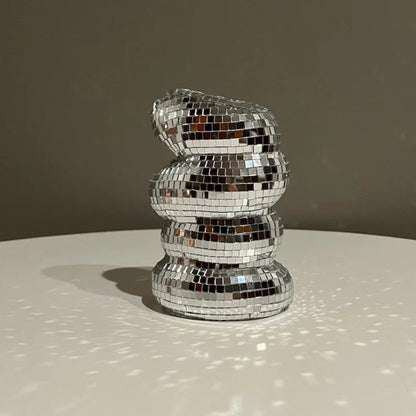 Decorative object made of reflective mosaic tiles on a neutral background