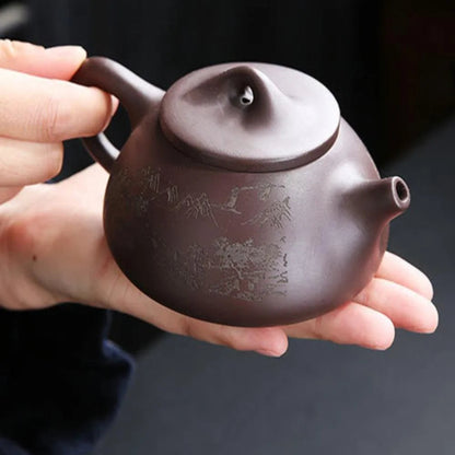 Person holding a purple teapot with engraved design on a dark background