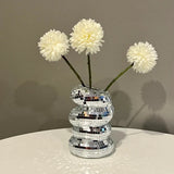 Silver mosaic vase with white flowers on a neutral background