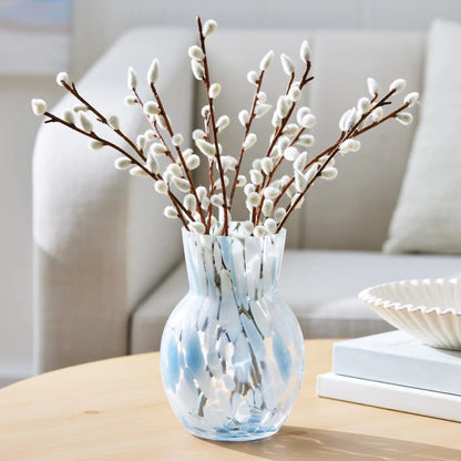 Decorative vase with willow branches on a table in a living room setting