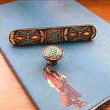 Decorative object with intricate patterns on a blue surface with an illustration of a person.
