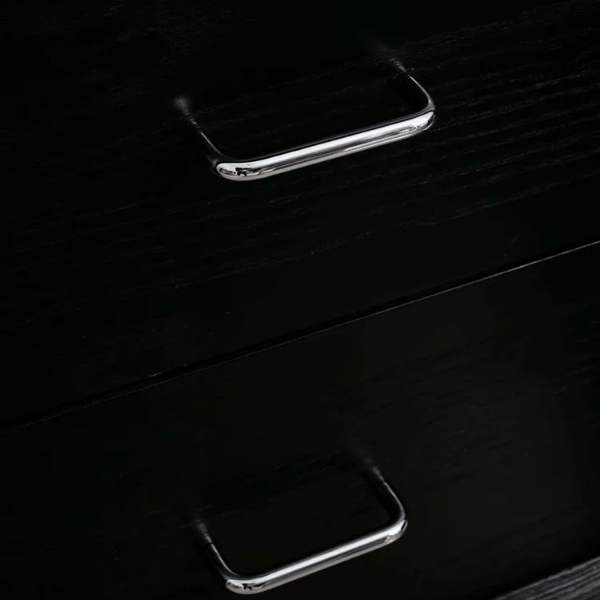 Two silver handle on a dark wooden surface