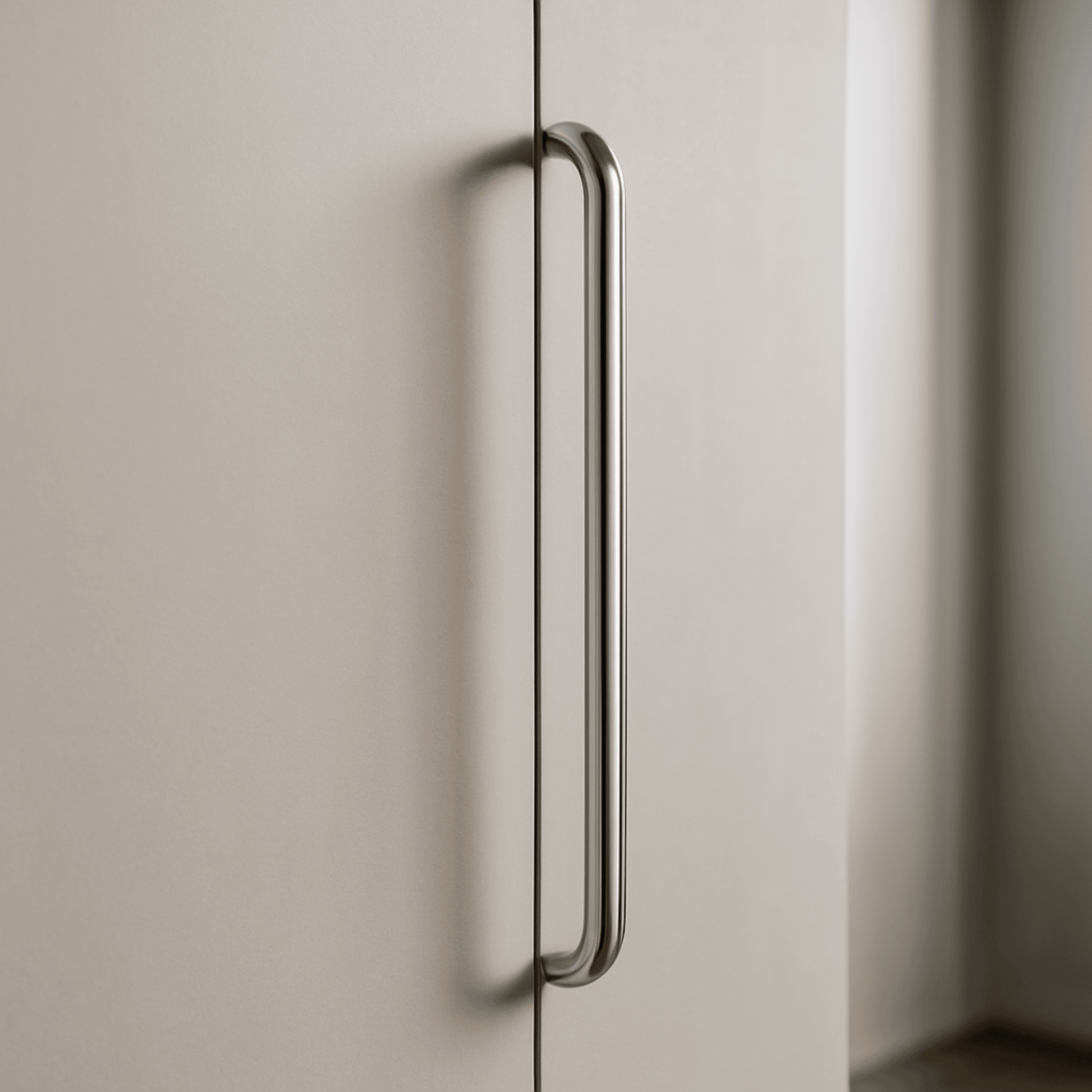 Metallic handle on a light-colored cabinet door