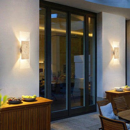Modern outdoor patio area with glass doors, wooden furniture, and decorative elements.