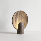 Cylindrical lamp with a round, textured shade on a light gray background
