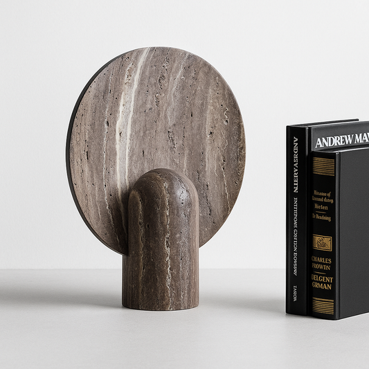 Decorative stone sculpture next to a book on a light gray background