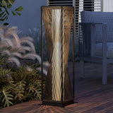 Decorative outdoor lamp on a wooden deck with plants and furniture in the background