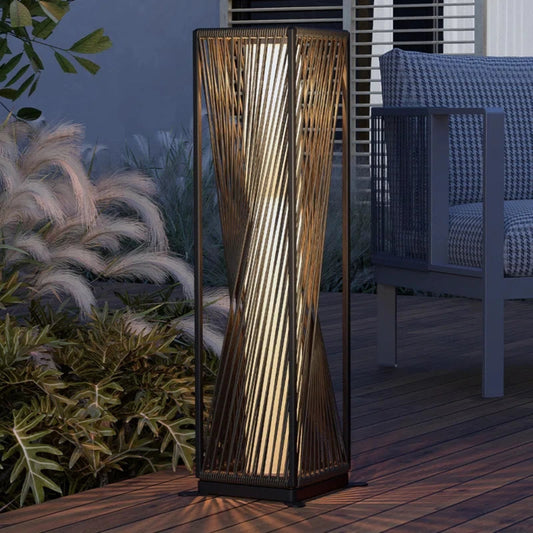 Decorative outdoor lamp on a wooden deck with plants and furniture in the background