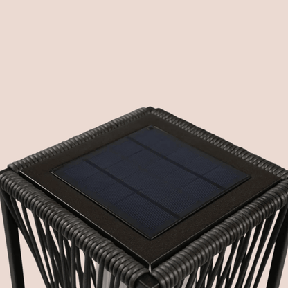Black woven side table with a solar panel on a beige background