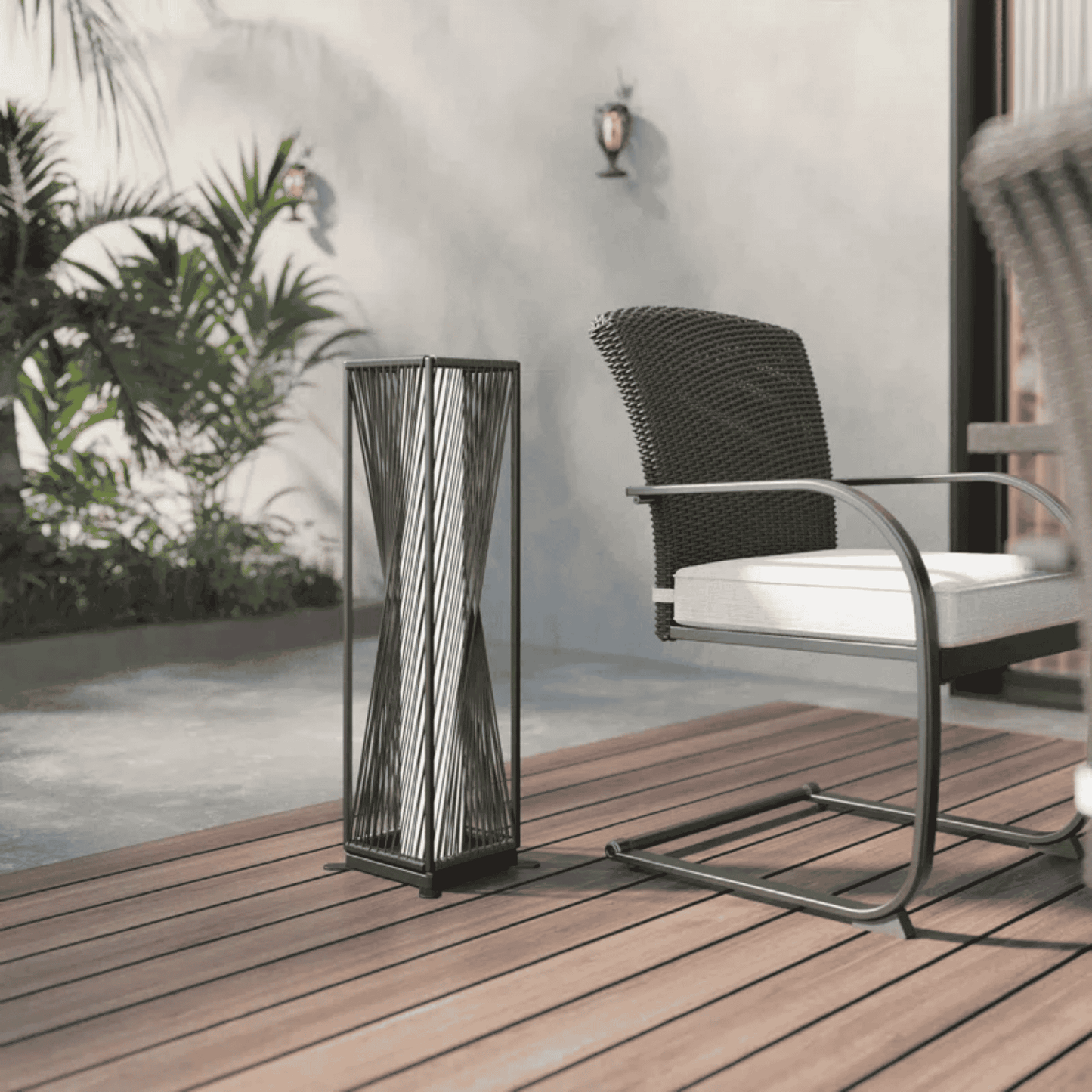 Decorative outdoor lamp on a wooden deck with a chair and plants in the background