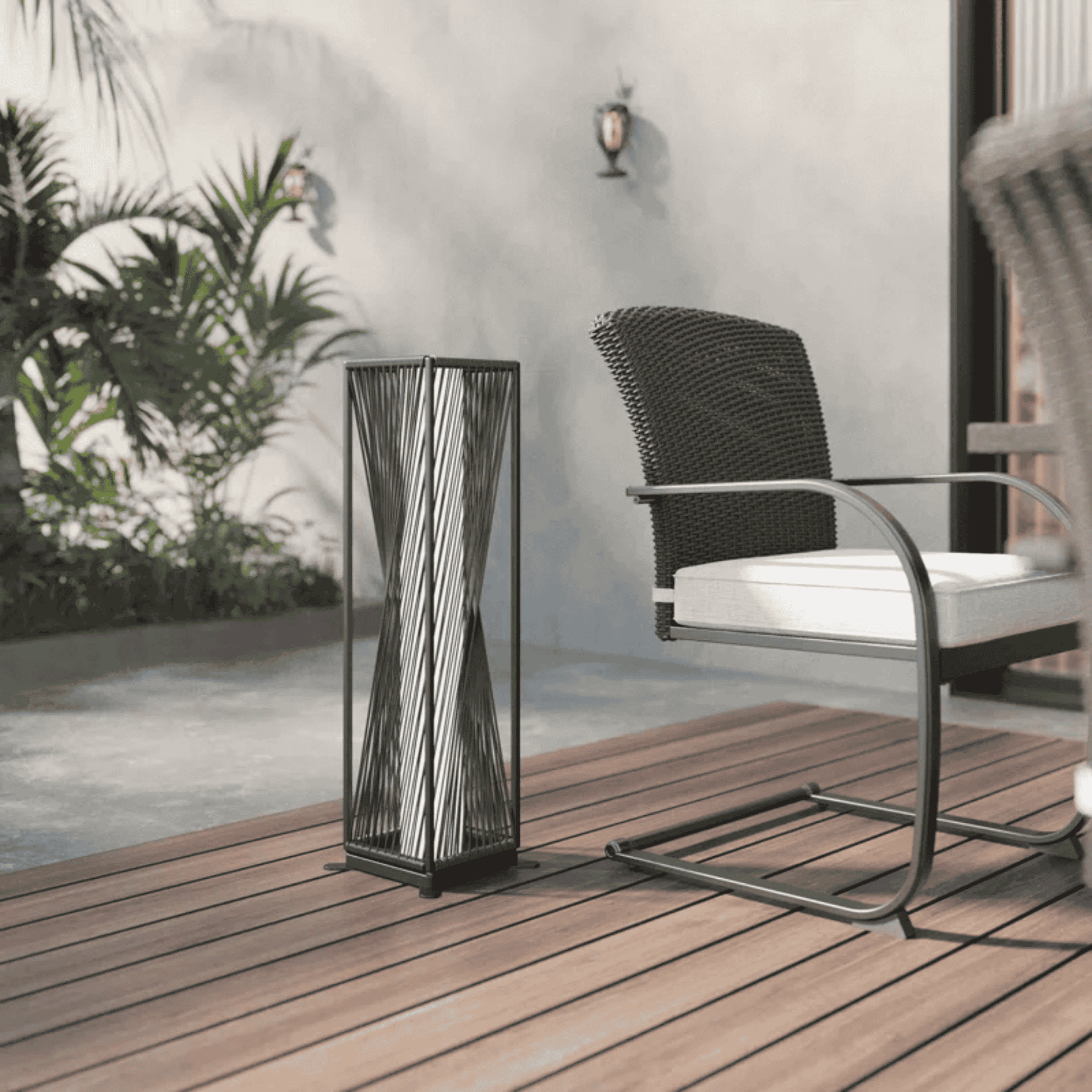 Decorative outdoor lamp on a wooden deck with a chair and plants in the background