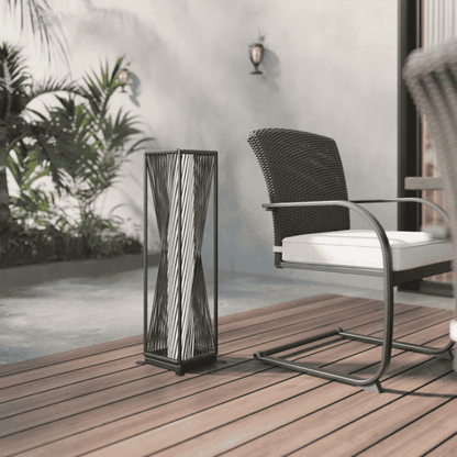 Decorative outdoor lamp on a wooden deck with a chair and plants in the background