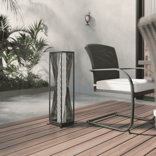 Decorative outdoor lamp on a wooden deck with a chair and plants in the background