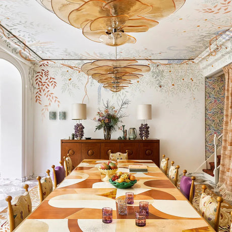 Dining room with a long wooden table, chairs, and decorative elements.