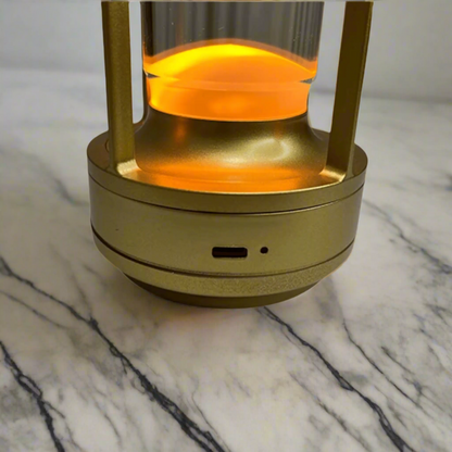 Gold-colored lantern with a glowing orange interior on a beige background