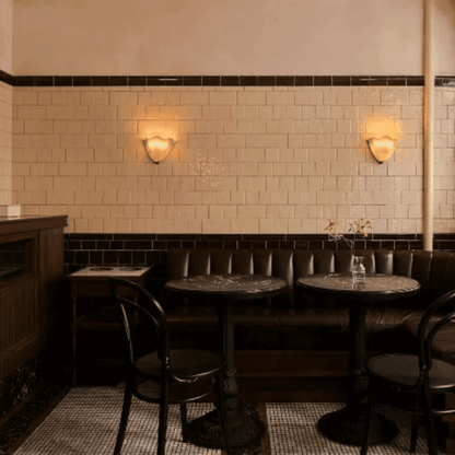 Dining area with tiled walls, tables, and chairs in a cozy setting.
