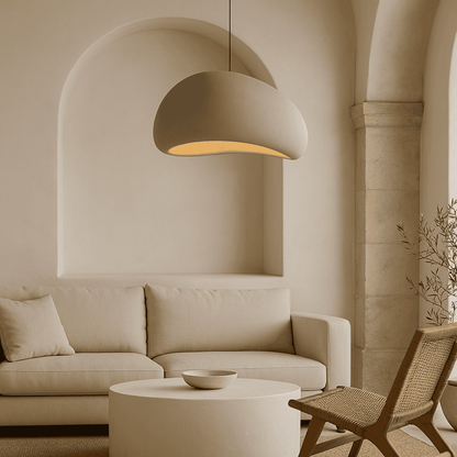 Modern living room with beige sofa, round coffee table, and pendant light.