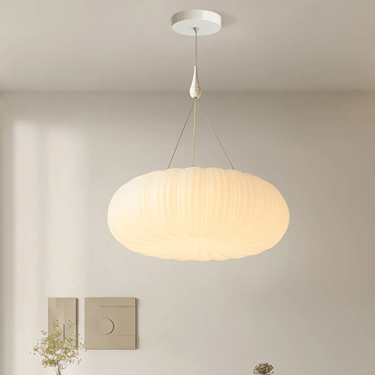 Modern pendant light hanging in a room with neutral walls and minimal decor.