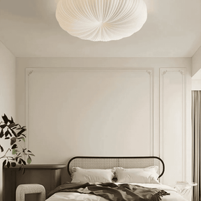 Modern bedroom with a bed, nightstand, and decorative light fixture.