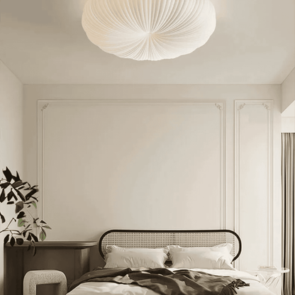 Modern bedroom with a bed, nightstand, and decorative light fixture.