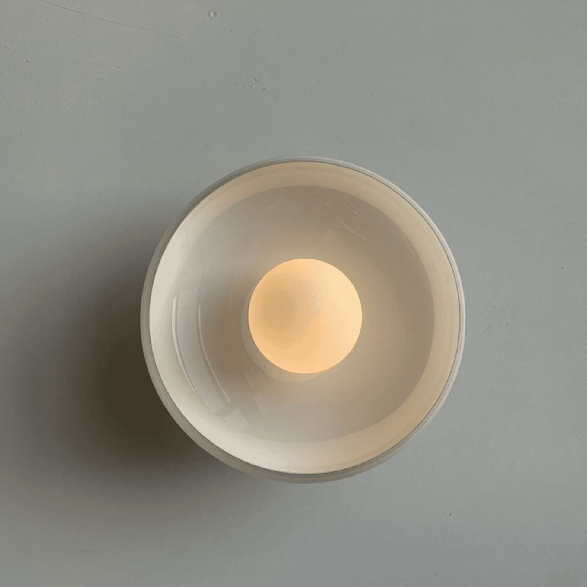 Round wall light fixture on a gray background
