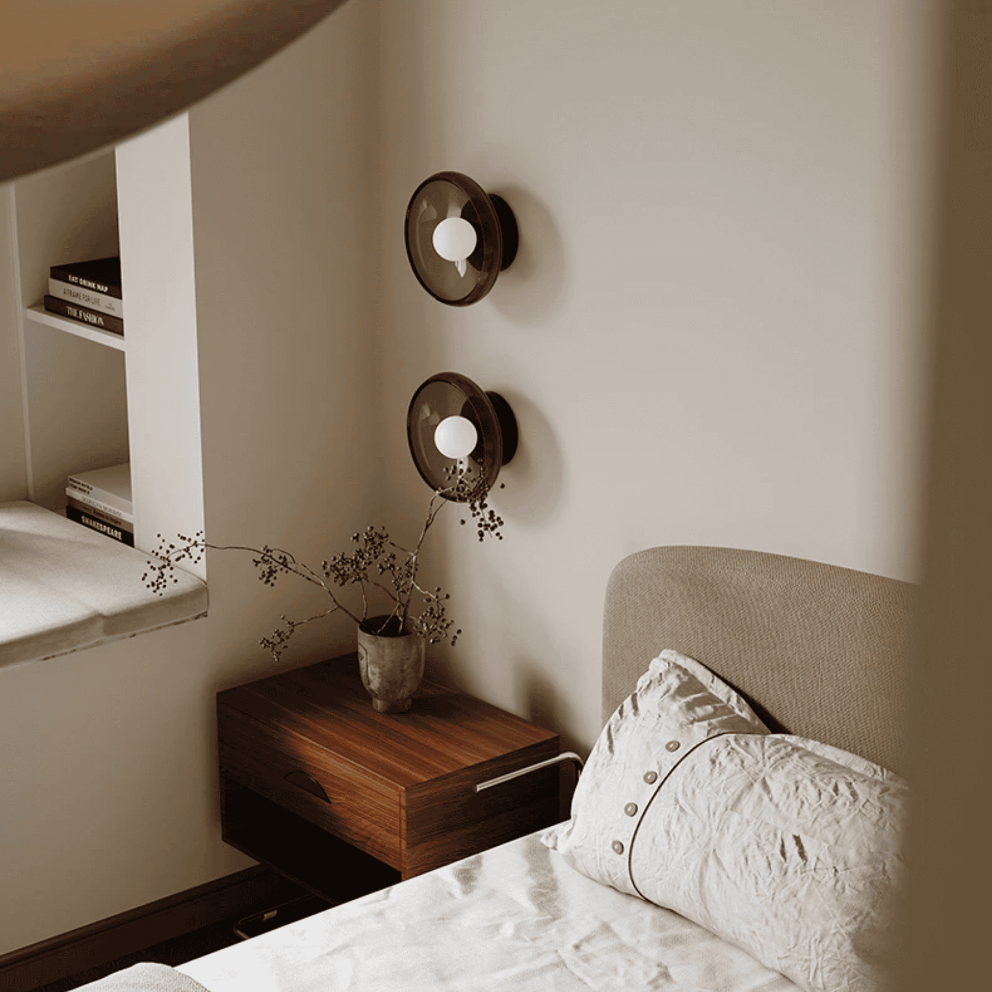 Bedroom with a bed, nightstand, and wall sconces.
