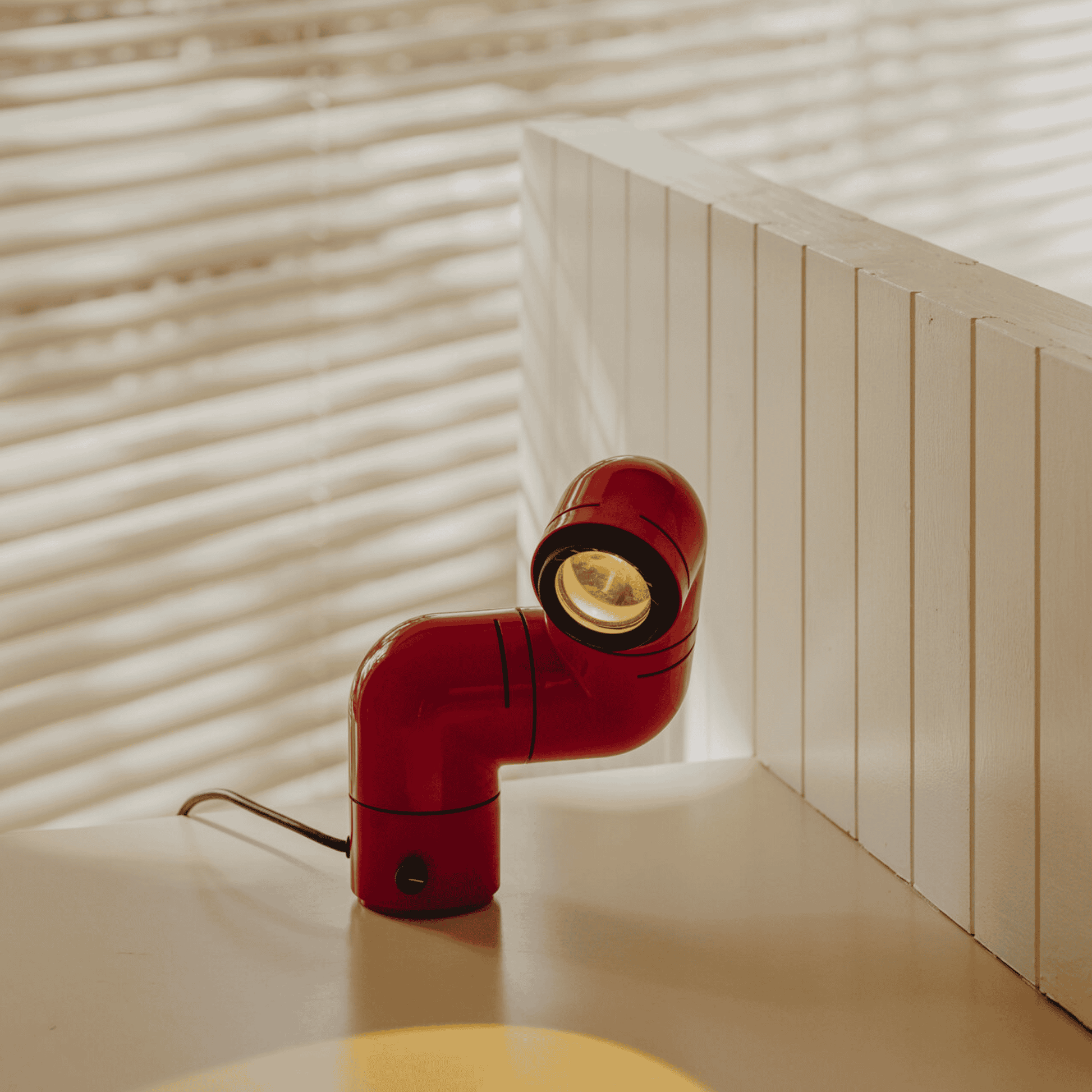 Red lamp with a unique design on a white surface