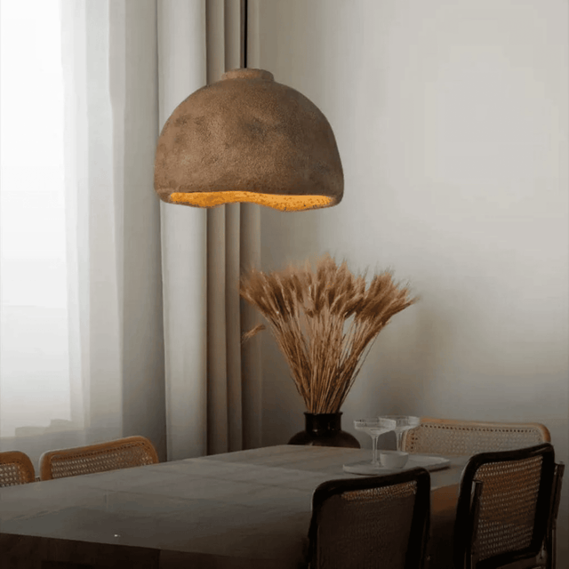 Dining room with a textured pendant light, table, and chairs.
