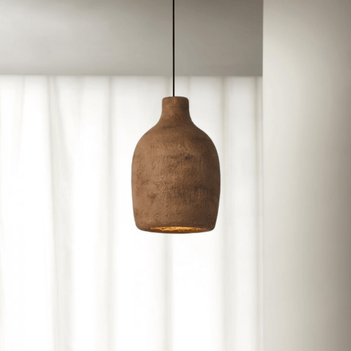 Brown pendant light hanging against a neutral background