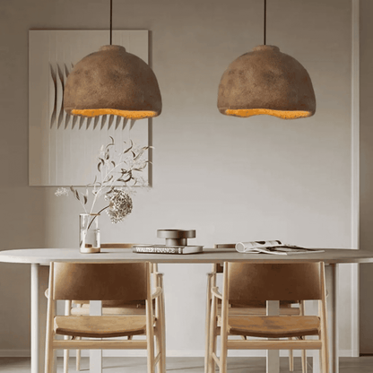 Dining room with two brown pendant lights, a table, and chairs.