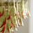 Close-up of a chandelier with gold and red glass shades on a neutral background