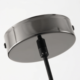 Round metallic object with a black cable on a light gray background