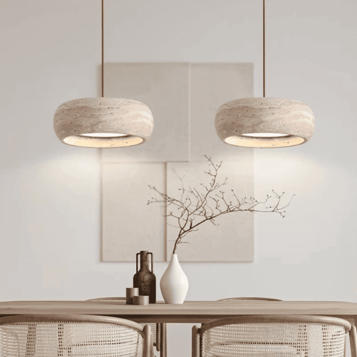 Two pendant lights hanging above a table with decorative items in a room.