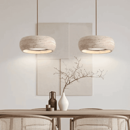 Two pendant lights hanging above a table with decorative items in a room.
